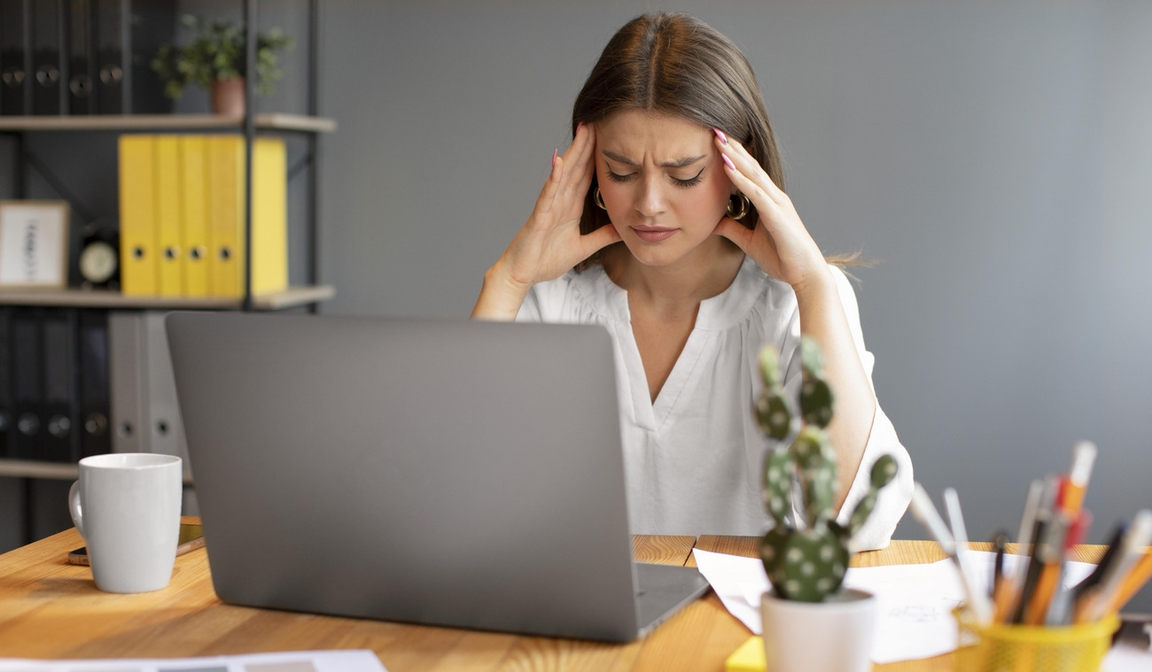 jeune-femme-ayant-mal-a-la-tete-au-travail