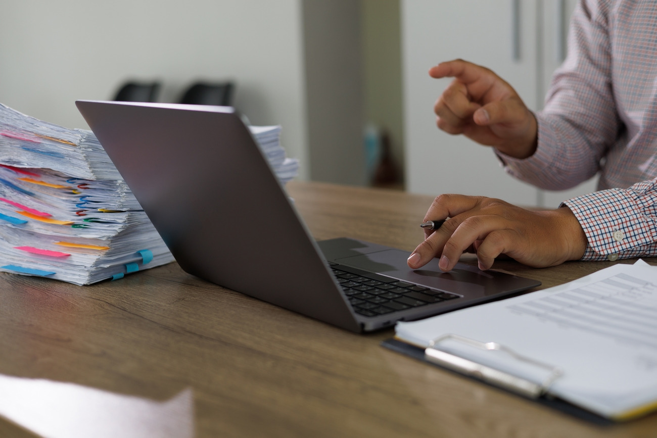 photographie-homme-daffaires-verifiant-documents-de-travail-sur-pc