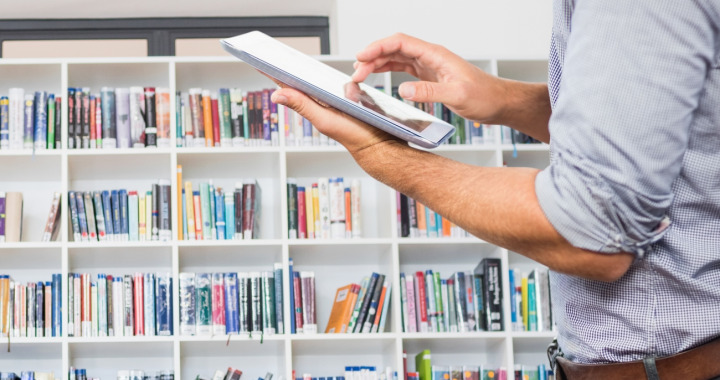 Si les bibliothèques physiques ont le vent en poupe dans les entreprises, les bibliothèques numériques, elles, déclinent légèrement. (Freepik/creativeart) l-homme-dans-une-bibliotheque-avec-une-tablette