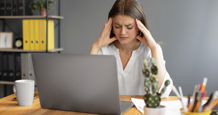 jeune-femme-ayant-mal-a-la-tete-au-travail