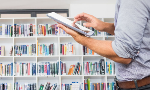 Si les bibliothèques physiques ont le vent en poupe dans les entreprises, les bibliothèques numériques, elles, déclinent légèrement. (Freepik/creativeart) l-homme-dans-une-bibliotheque-avec-une-tablette