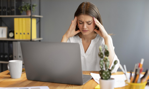 jeune-femme-ayant-mal-a-la-tete-au-travail